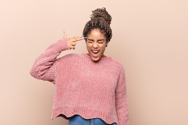 Jeune femme afro crier fort et en colère isolé