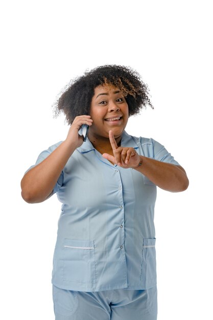 jeune femme afro latine infirmière debout à l'aide de son téléphone image verticale sur fond blanc