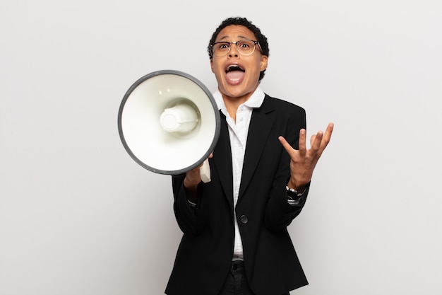 Jeune femme afro noire à la recherche désespérée et frustrée, stressée, malheureuse et agacée, criant et criant