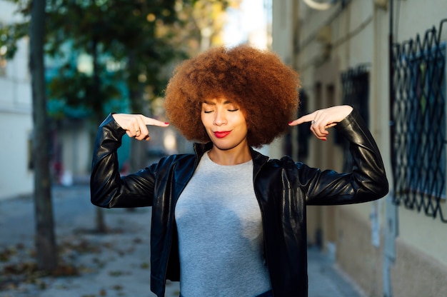 Jeune femme afro pointant vers elle-même