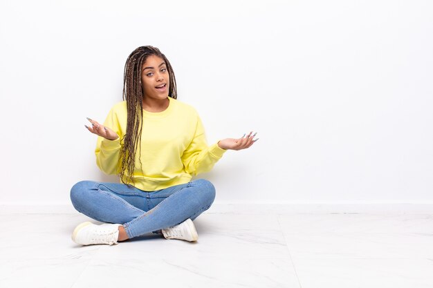 Jeune femme afro à la recherche de bonheur, arrogant, fier et satisfait de soi, se sentant comme un numéro un