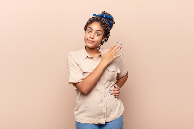 Jeune femme afro se sentant confuse et désemparée, s'interrogeant sur une explication ou une pensée douteuse