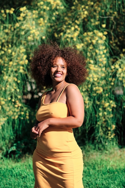 Jeune femme afro sinueuse vêtue de jaune un jour d'été