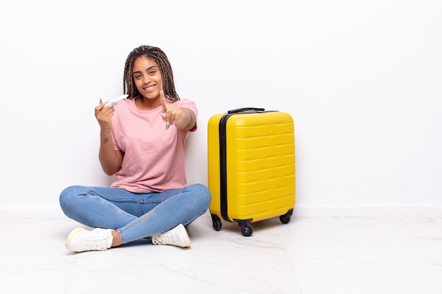 Jeune femme afro souriant fièrement et en toute confiance en faisant la pose triomphante