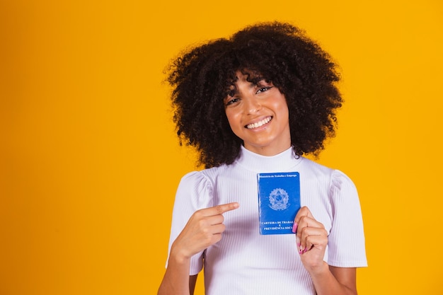 Jeune femme afro tenant une carte de travail brésilienne. Réforme du travail, fgts, salaire et concept de travailleur formel