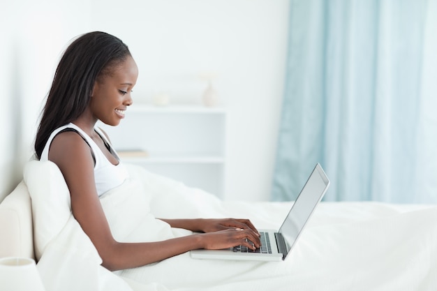 Jeune femme à l&#39;aide d&#39;un cahier avant de dormir