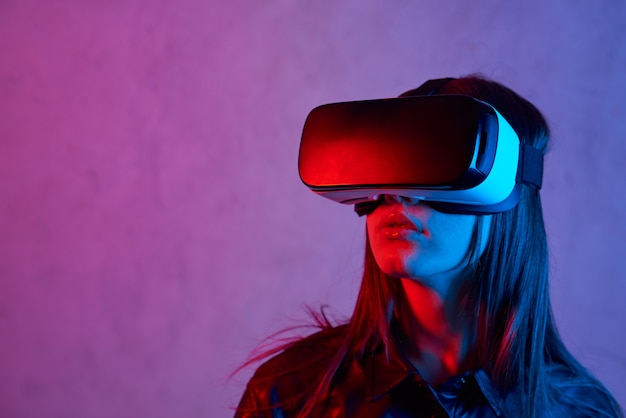 Jeune femme à l'aide d'un casque de réalité virtuelle tout en portant une veste