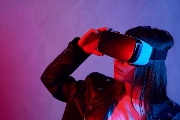 Jeune femme à l'aide d'un casque de réalité virtuelle tout en portant une veste
