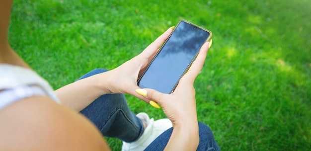 Jeune femme à l'aide de téléphone portable à l'extérieur