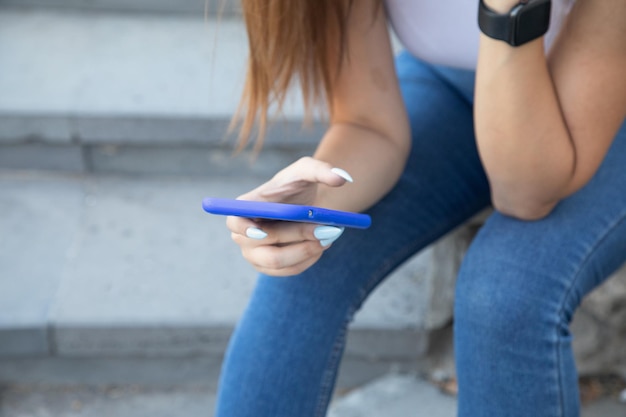 Jeune femme à l'aide de téléphone portable à l'extérieur