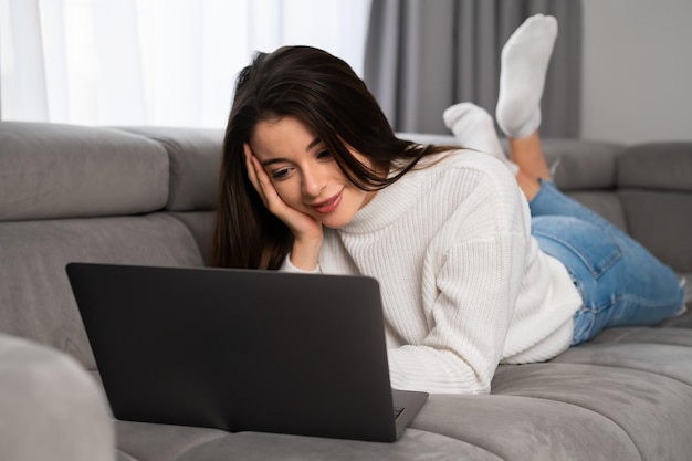 Jeune femme aime discuter avec des amis via un ordinateur portable moderne