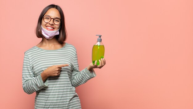 Jeune femme à l'air excitée et surprise pointant sur le côté et vers le haut pour copier l'espace