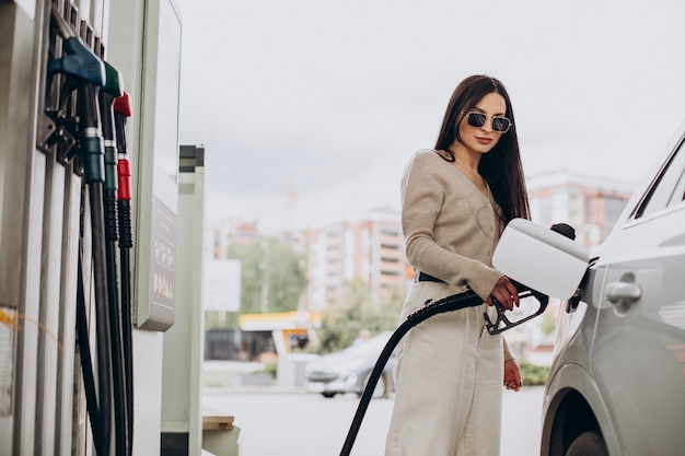 Jeune femme alimentant sa voiture