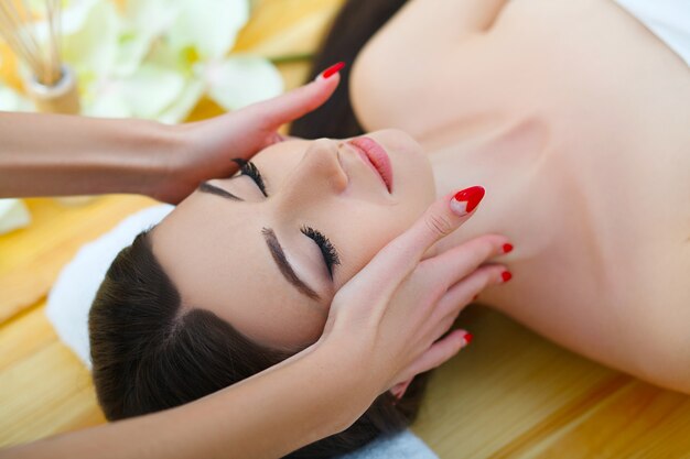 Jeune femme allongée sur une table de massage, relaxant les yeux fermés. Femme. Salon spa