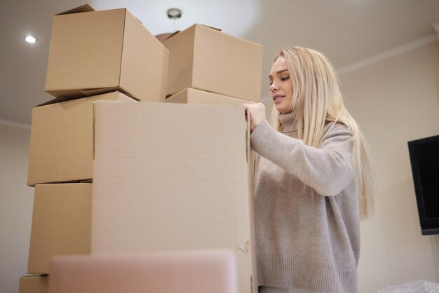 Jeune femme américaine heureuse avec pile de boîtes en carton