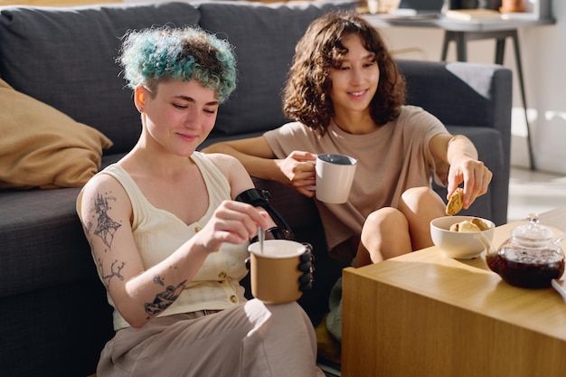 Jeune femme amputée avec une main myoélectrique tenant une tasse avec du thé sur son genou