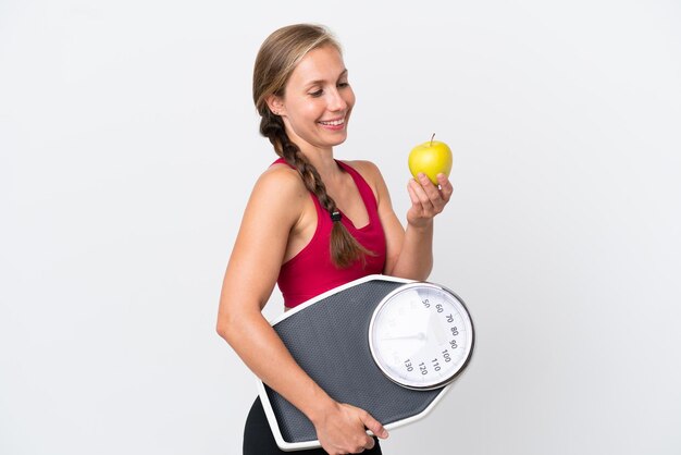 Jeune femme anglaise isolée sur fond blanc avec balance et avec une pomme