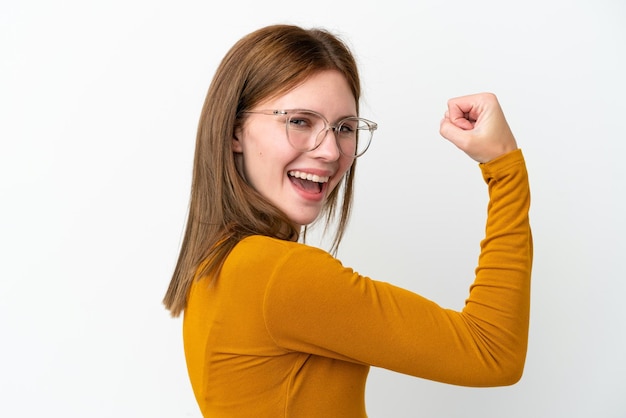 Jeune femme anglaise isolée sur fond blanc avec des lunettes et célébrant une victoire