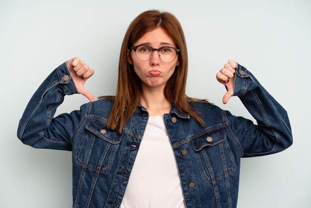 Jeune femme anglaise isolée sur fond bleu montrant un geste d'aversion vers le bas Concept de désaccord