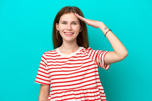 Jeune femme anglaise isolée sur fond bleu saluant avec la main avec une expression heureuse