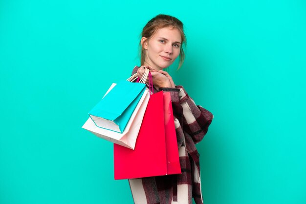 Photo jeune femme anglaise isolée sur fond bleu tenant des sacs à provisions