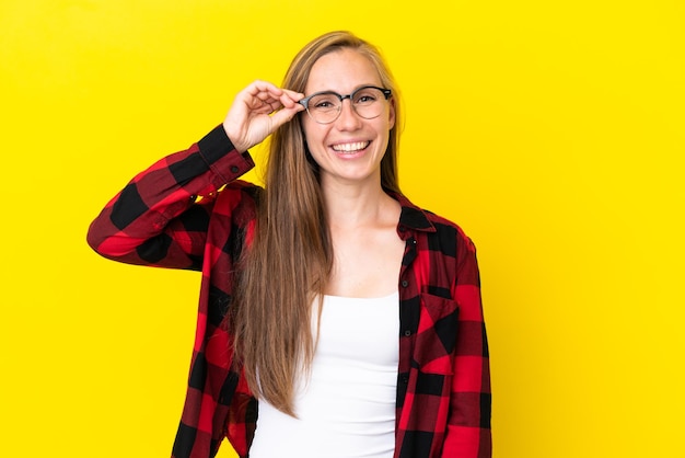 Jeune femme anglaise isolée sur fond jaune montrant un signe ok avec les doigts