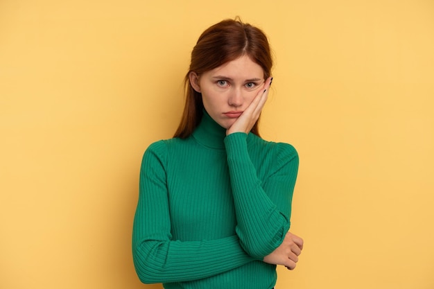 Jeune femme anglaise isolée sur fond jaune qui s'ennuie, est fatiguée et a besoin d'une journée de détente.