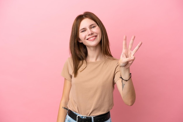 Jeune femme anglaise isolée sur fond rose heureuse et comptant trois avec les doigts