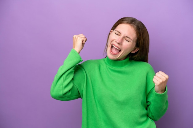 Jeune femme anglaise isolée sur fond violet célébrant une victoire