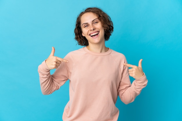 Jeune femme anglaise isolée sur le mur bleu fier et satisfait de soi