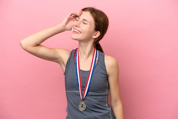 Jeune femme anglaise avec des médailles isolées sur fond rose a réalisé quelque chose et a l'intention de trouver la solution