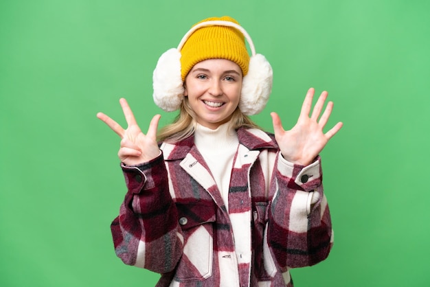 Jeune femme anglaise portant des manchons d'hiver sur fond isolé comptant huit avec les doigts