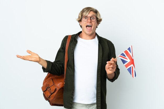 Jeune femme anglaise tenant un drapeau du Royaume-Uni avec une expression faciale choquée