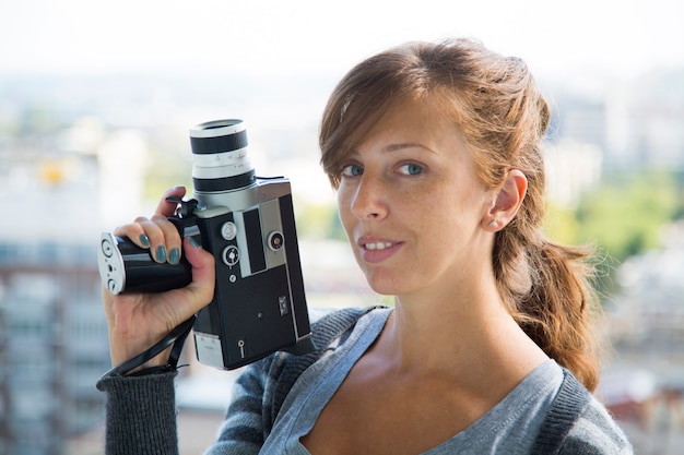 Jeune femme avec appareil photo vintage