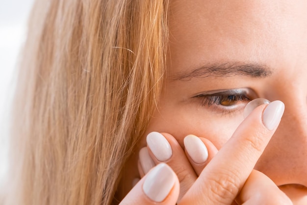 Jeune femme appliquant des lentilles de contact pour améliorer la vision