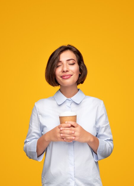 Jeune femme appréciant le café le matin