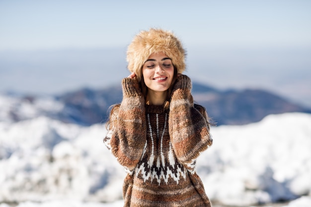 Jeune femme appréciant les montagnes enneigées en hiver