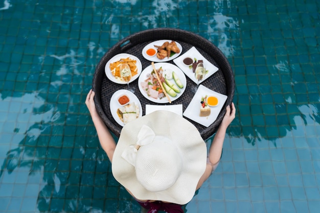 Jeune Femme Appréciant Avec De La Nourriture Flottante Dans La Piscine