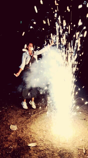 Photo une jeune femme apprécie les feux d'artifice la nuit.