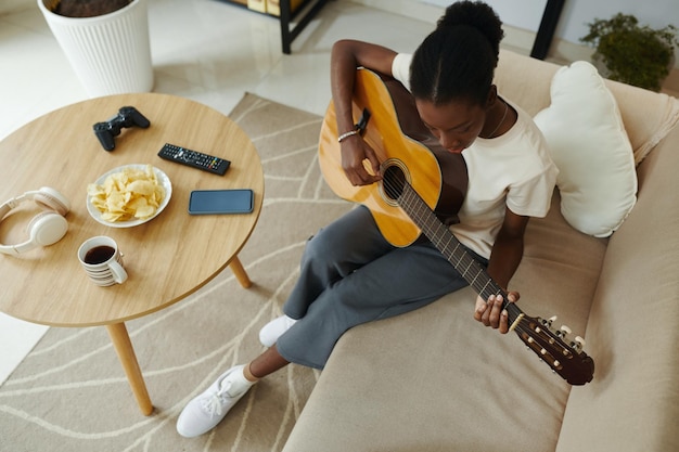 Photo une jeune femme apprend à jouer de la guitare.