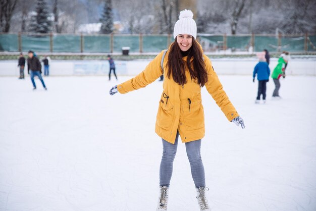 Une jeune femme apprend à skier à la patinoire de la ville