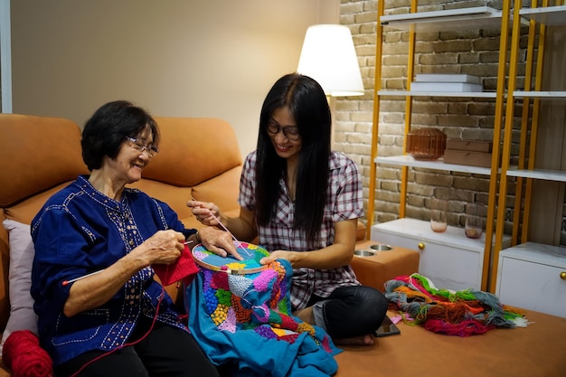 Une jeune femme apprend le tricot à la main d'une personne âgée comme passe-temps