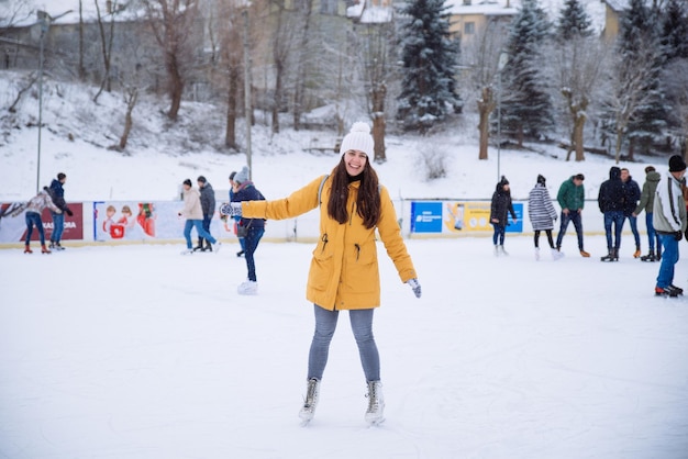 Jeune femme apprendre à skier à la patinoire de la ville