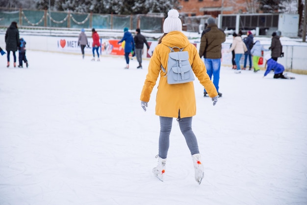 Jeune femme apprendre à skier à la patinoire de la ville