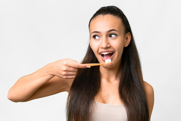 Jeune femme arabe sur fond blanc isolé avec une brosse à dents