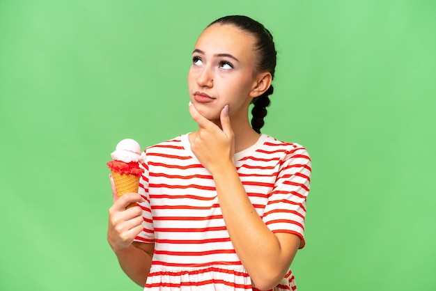 Jeune femme arabe avec une glace au cornet sur fond isolé ayant des doutes