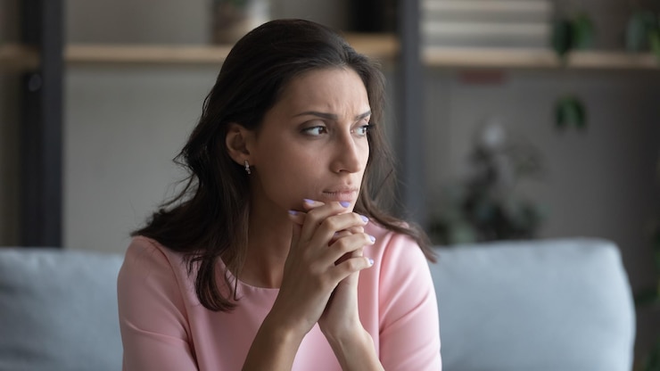 Photo jeune femme arabe indienne inquiète assise sur le canapé à la maison regarde à distance réfléchissant réfléchissant anxieuse malheureuse arabe de race mixte femme souffre de problèmes psychologiques personnels pleure ou aspire