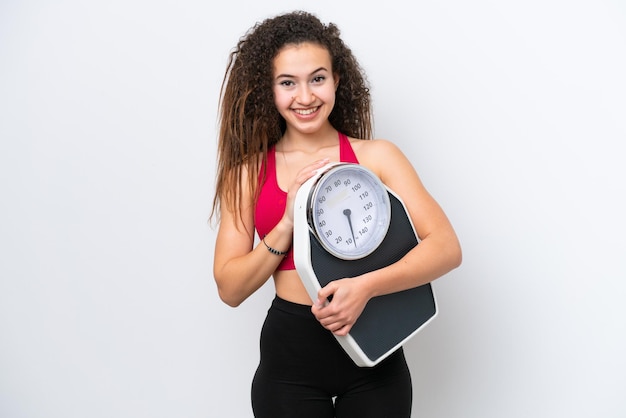 Jeune femme arabe isolée sur fond blanc avec balance