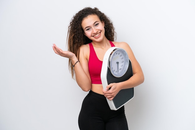 Jeune femme arabe isolée sur fond blanc avec balance