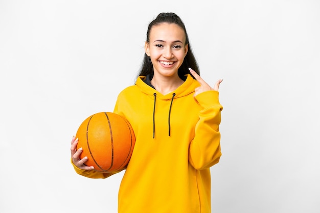 Jeune femme arabe jouant au basket-ball sur fond blanc isolé donnant un geste du pouce levé